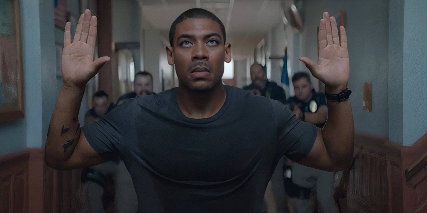 Эйрон Пир как Терри Ричмонд, держащий руки в воздухе в *Rebel Ridge*