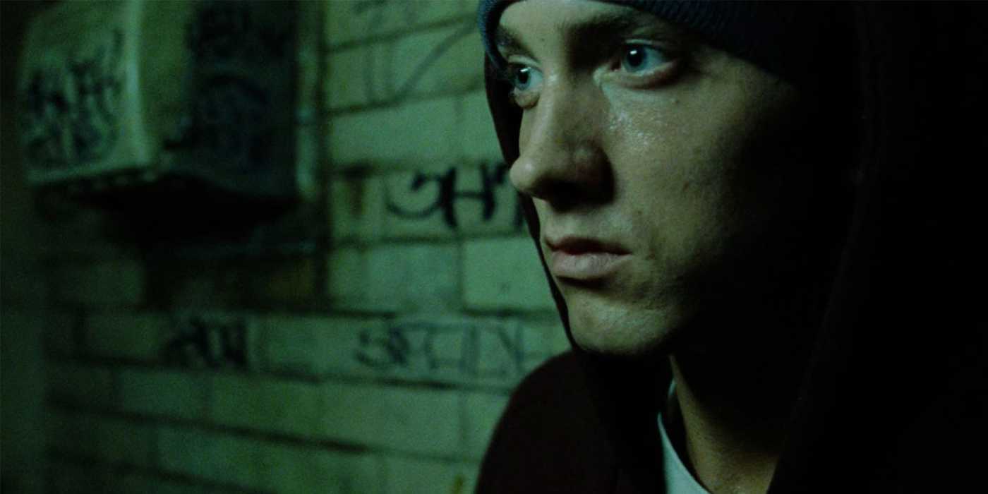 Эмминэм сидит у стены с граффити в 8 Mile.