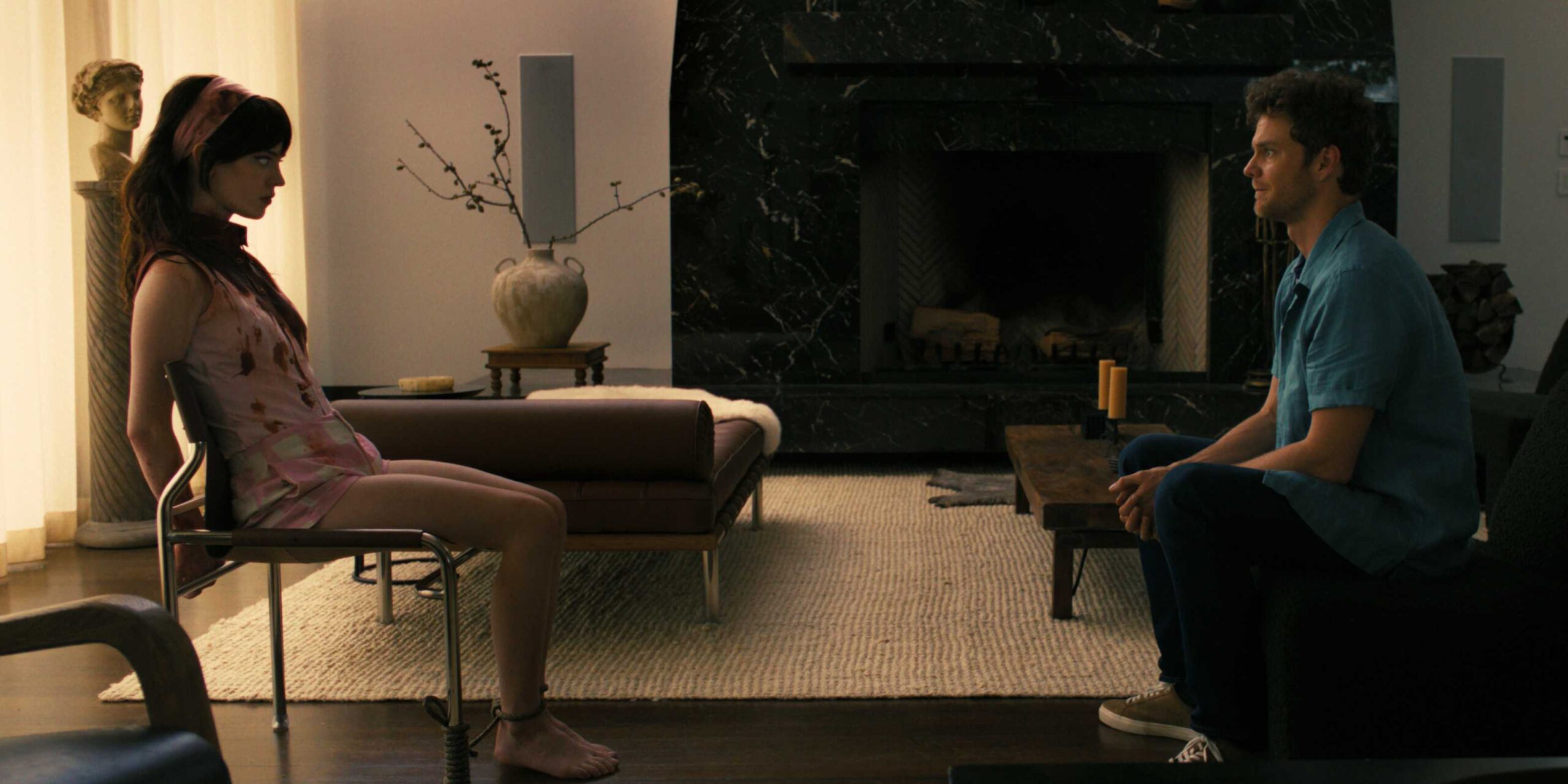 ДжОш сидит напротив кровистой Ирис, которая привязана к стулу, в Companion