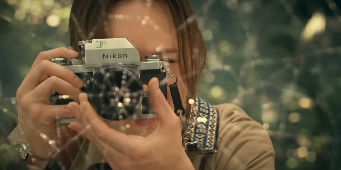 Керри Биш в роли Констанс Веб в фильме "Мадам Веб" делает фотографию с камерой