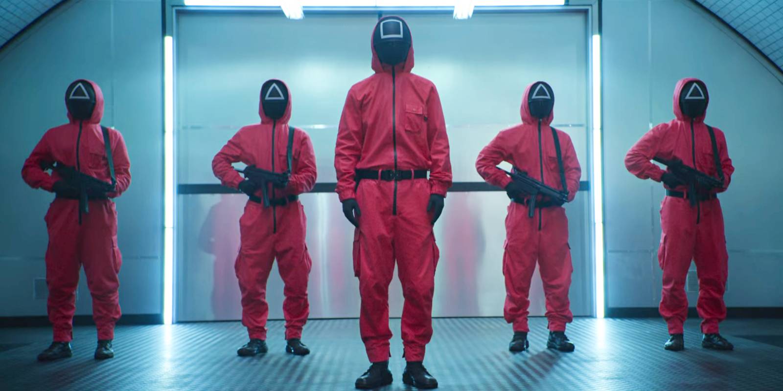 Маскированные охранники, держащие в руках оружие в *Squid Game*