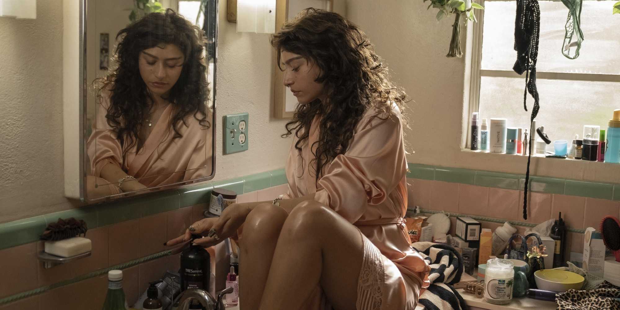 Одесса Эйцион в роли Талула в I Love LA, сидя с ногами в раковине.