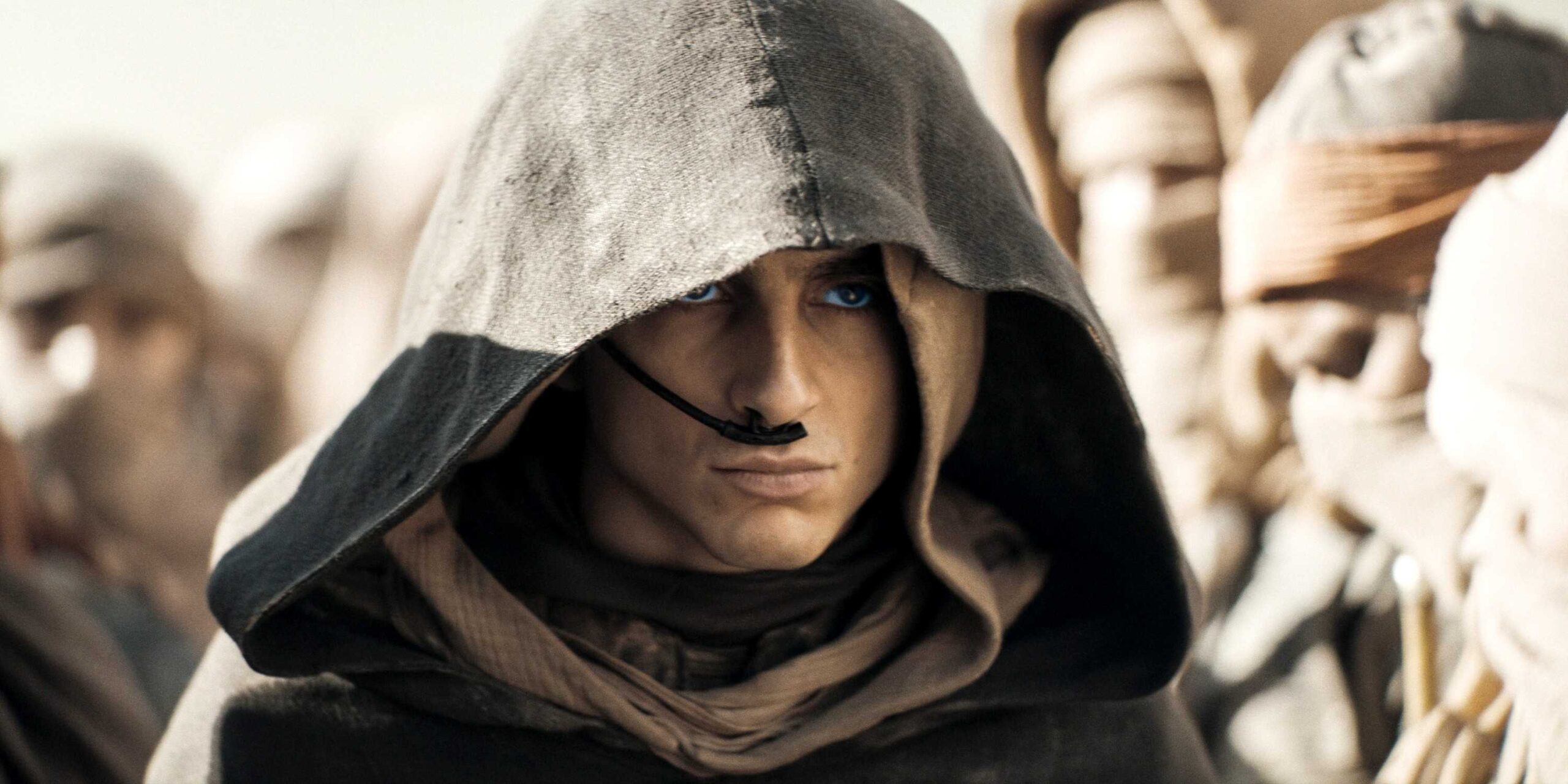 Пол Атрейдис, стоящий среди ференов с поднятым капюшоном в Dune: Часть 2