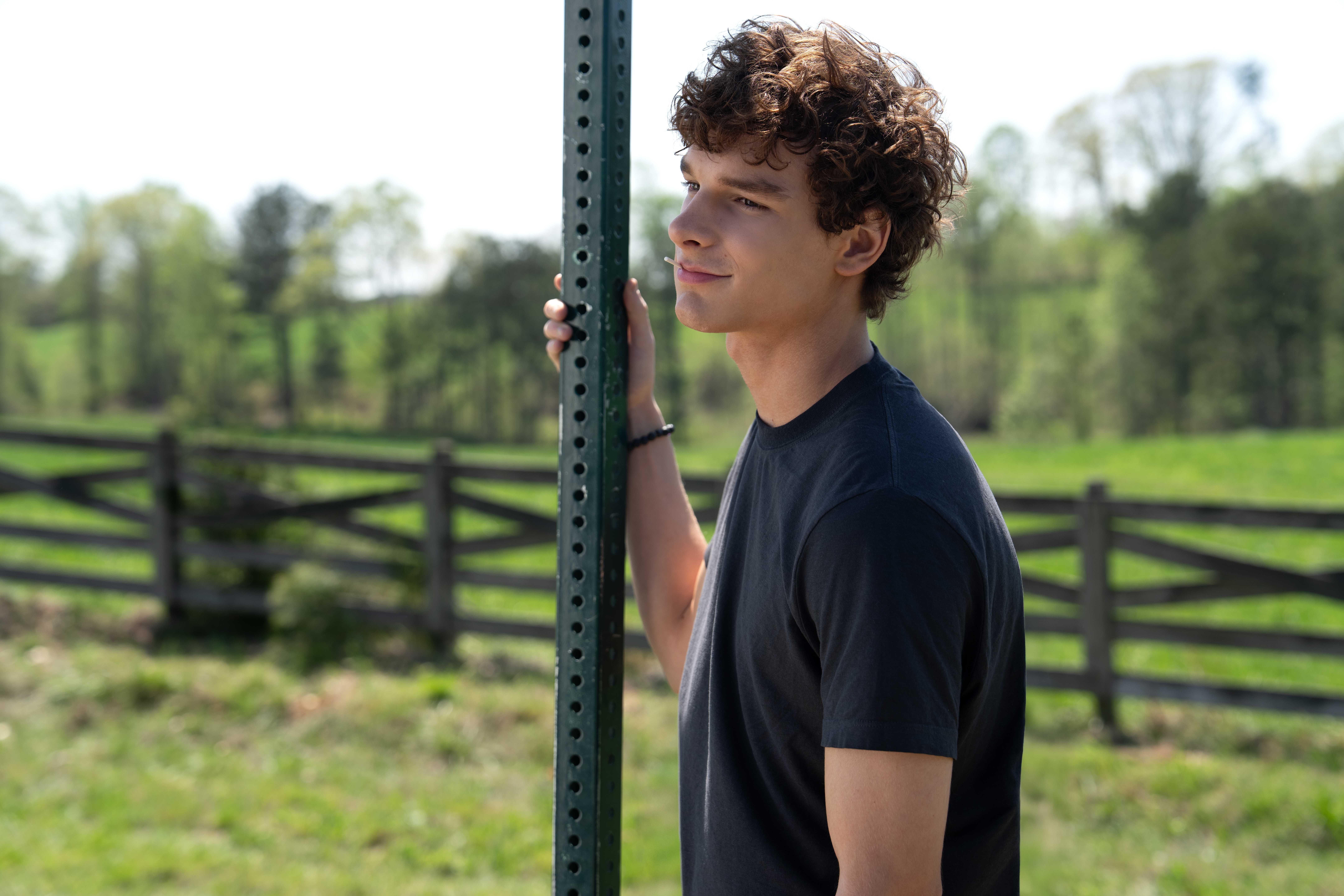 Мейсон Тамс в роли Майлера Эда, стоящего рядом со знаком на дороге в фильме "Regretting You"