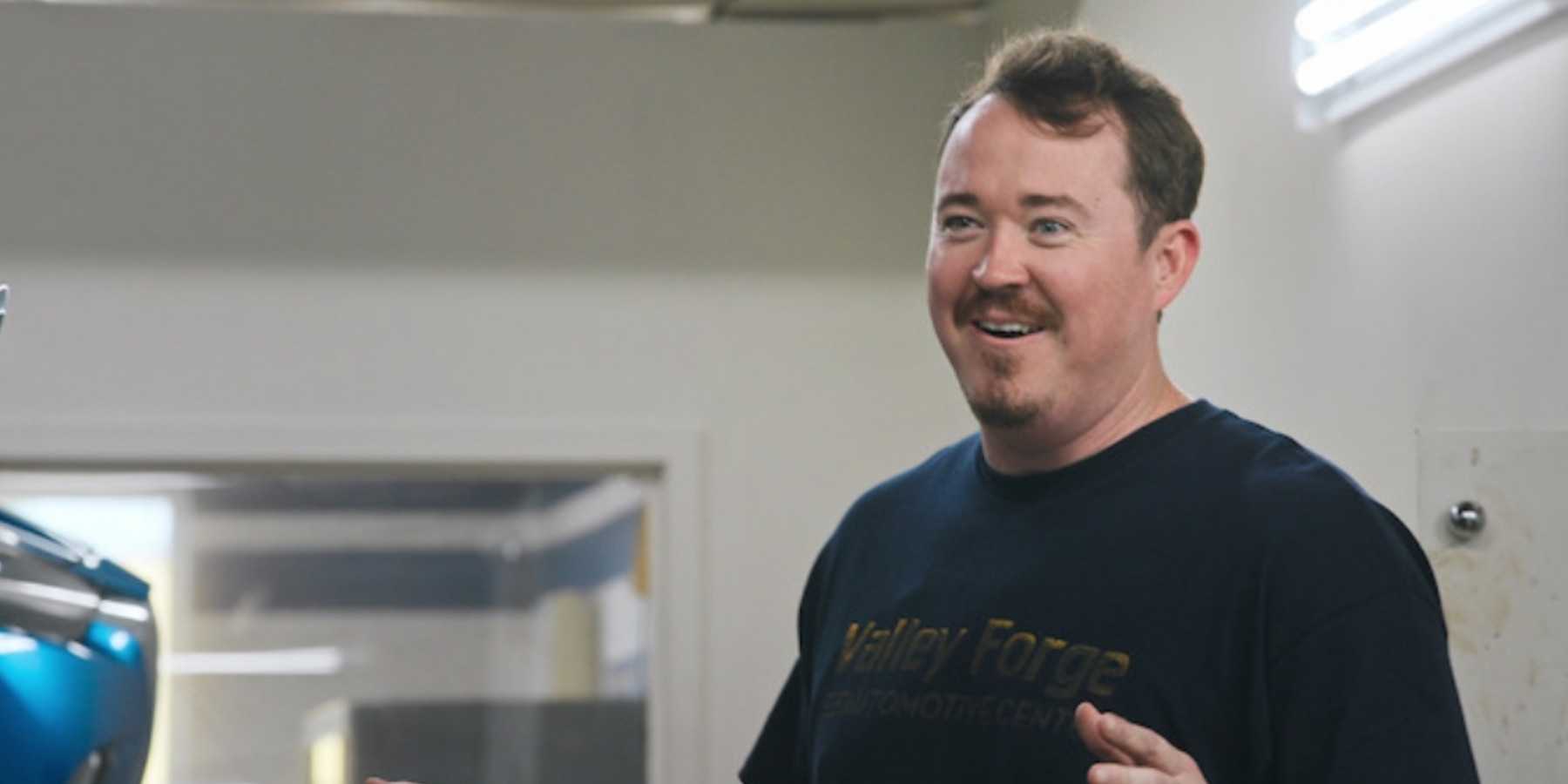 Шейн Гиллис, улыбающийся и в футболке Valley Forge Automotive Center