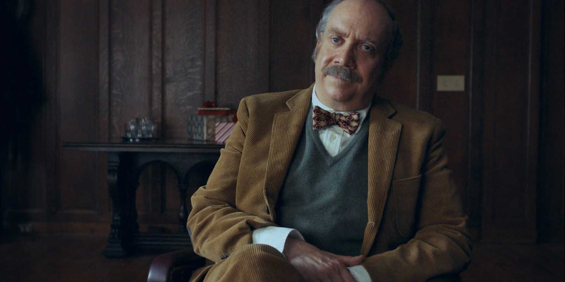 Пол Джиаммати в роли Пола Хунхема, сидящий в кабинете в фильме "The Holdovers".