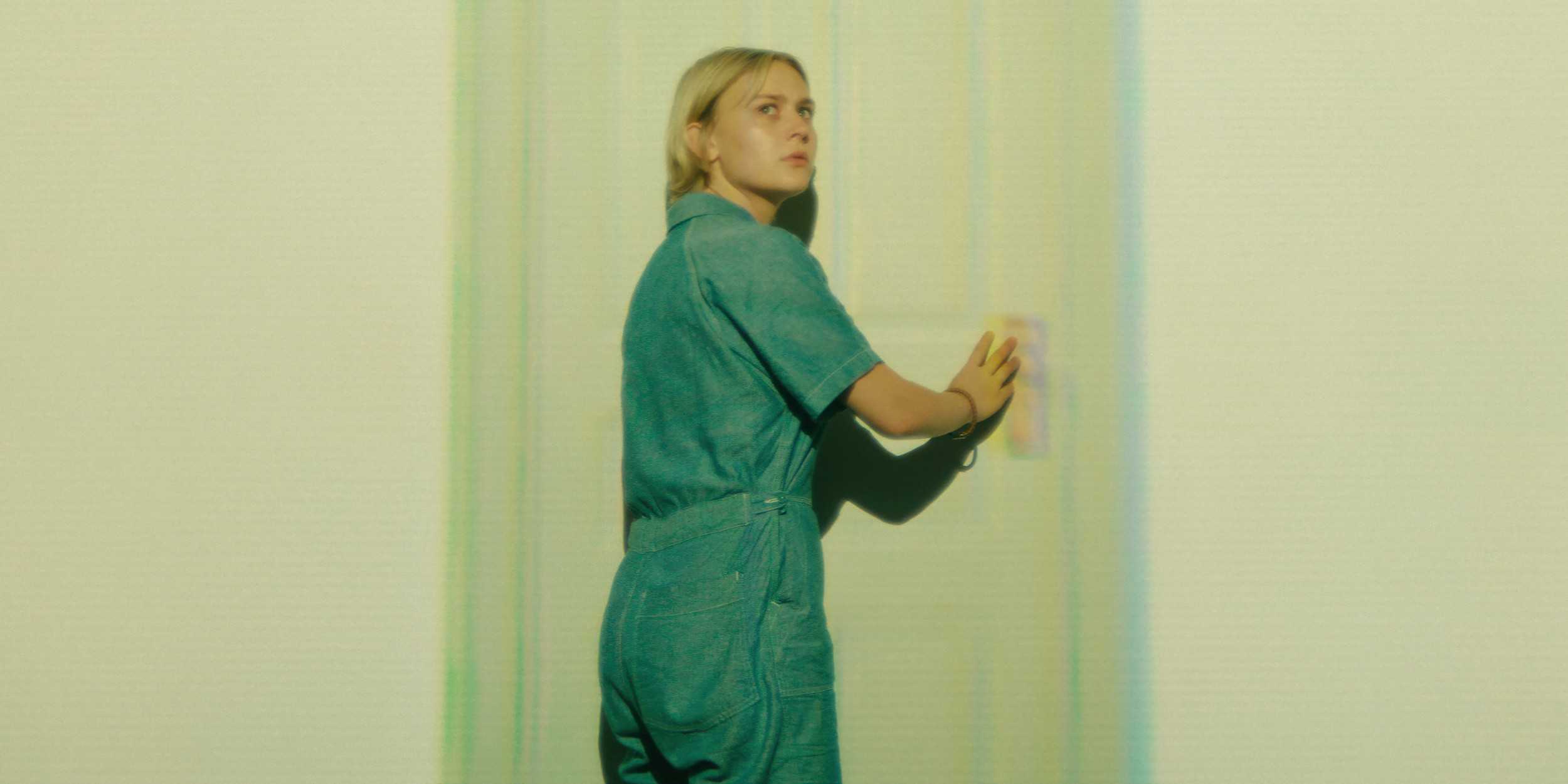 Леила тянется к дверной ручке в 3-й эпизоде 1 сезона сериала "Wayward", одновременно оглядываясь.