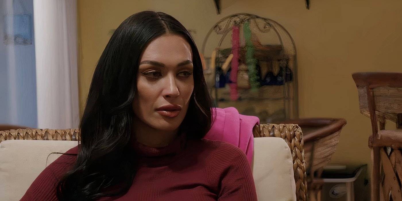 Amani Jlassi из "90 Day Fiance" сидит в кресле в темном розовом топе