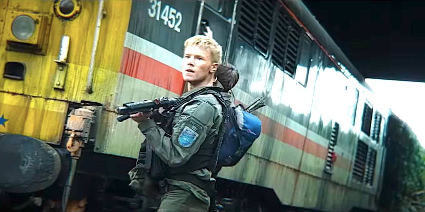 Солдат держит оружие и выглядит испуганным рядом с заброшенным поездом в трейлере "28 дней спустя".