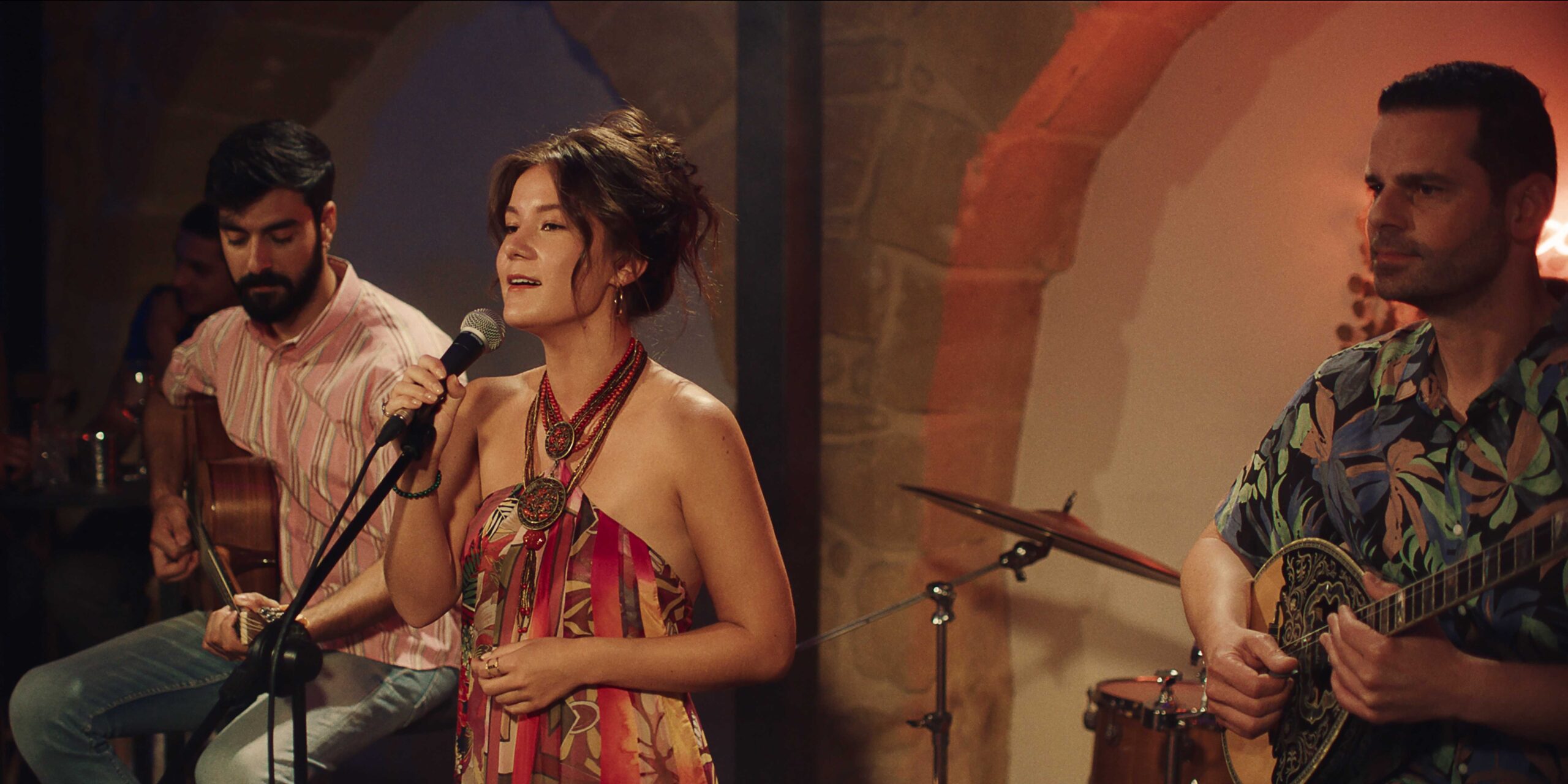 Мелина поет, держа микрофон в кадре Find Me Falling