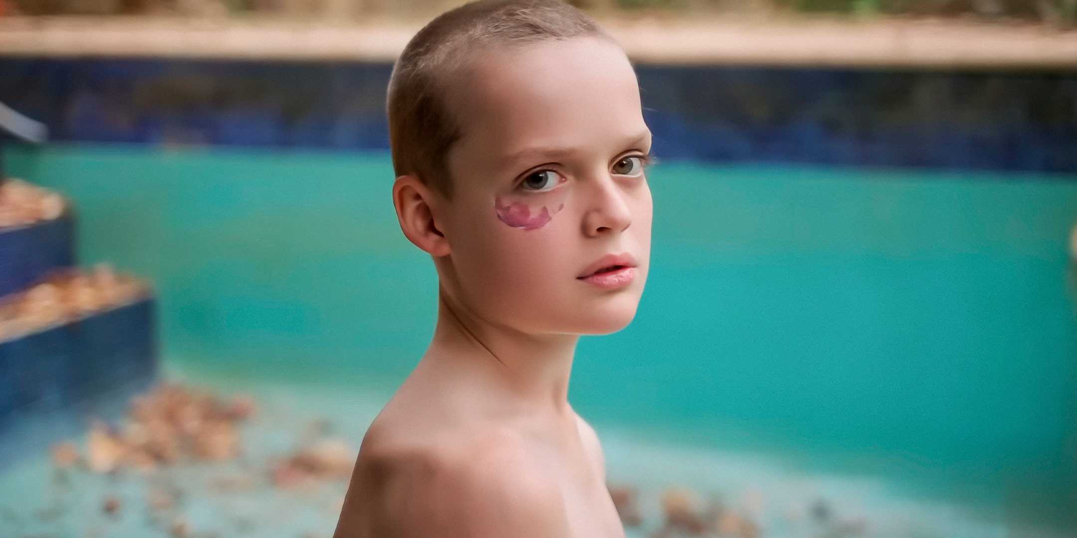 Ребенок с родинкой под глазом, смотрящий в камеру в Bring Her Back
