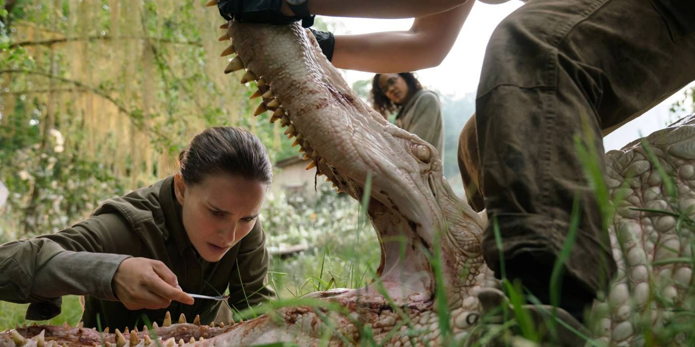 Лена (Натали Портман) смотрит в пасть рептилии, в то время как другая женщина держит ее открытой в фильме Annihilation