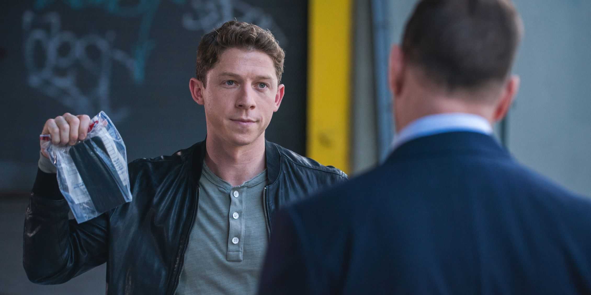 Джо Хилл из *Blue Bloods* триумфально держит в руках телефон в паке с вещественными доказательствами, разговаривая с Дэнни