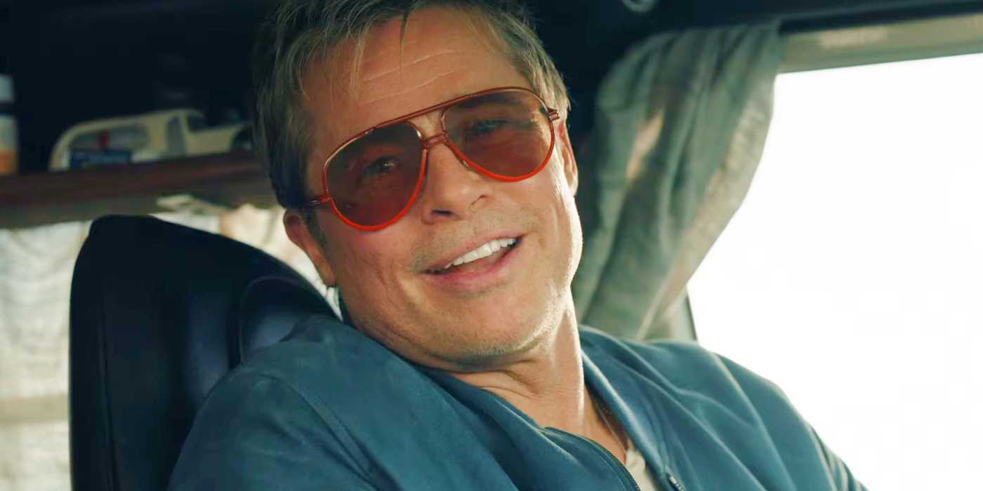 Брэд Пит в роли Сонни Хейса, улыбающийся в солнцезащитных очках в фильме "F1: Гонка"