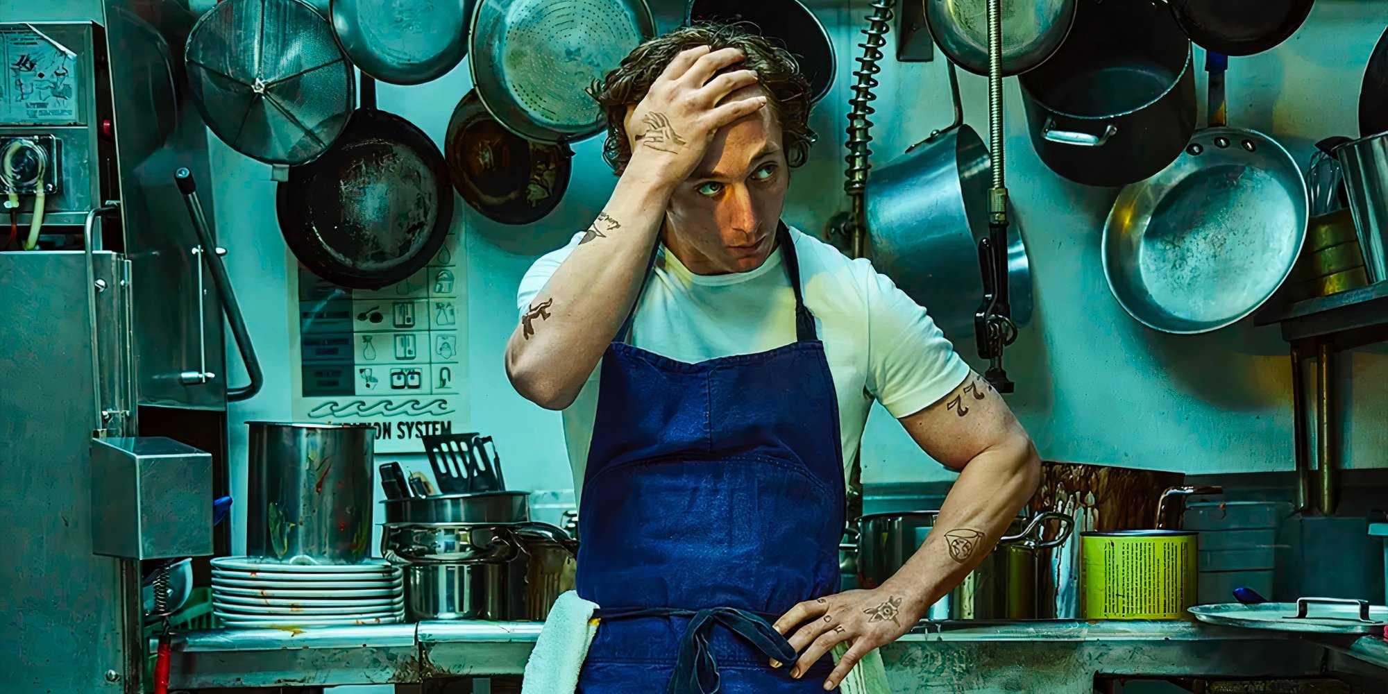 Кармин в белой футболке и синей куртке, одна рука на голове, другая на бедре, смотрит в сторону