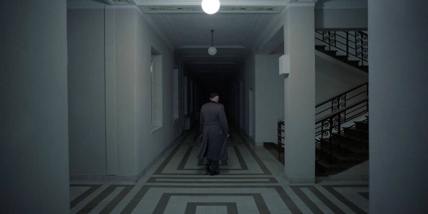 Кристиан Фридель в роли Рудольфа Хёсса, идущего по лестнице в финале фильма "The Zone of Interest"