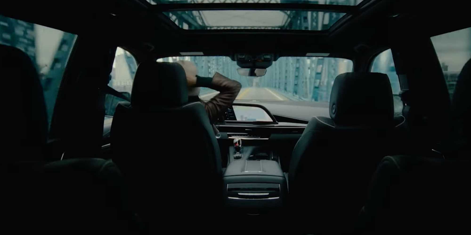 Изображение "Контроль" с Келли Мари Тран, которая чешет голову, во время вождения по мосту на машине