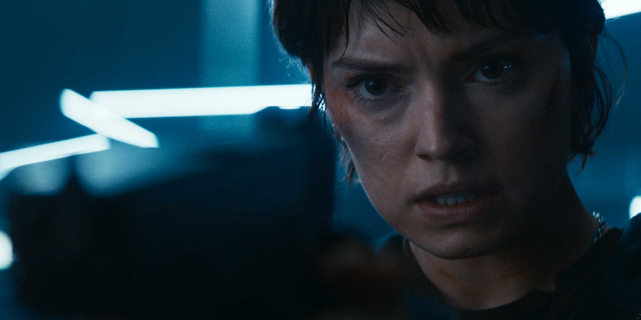 Дейзи Ридли в роли Джой, указывающей на пистолет, размытый в фокусе, перед ней в фильме "Cleaner"