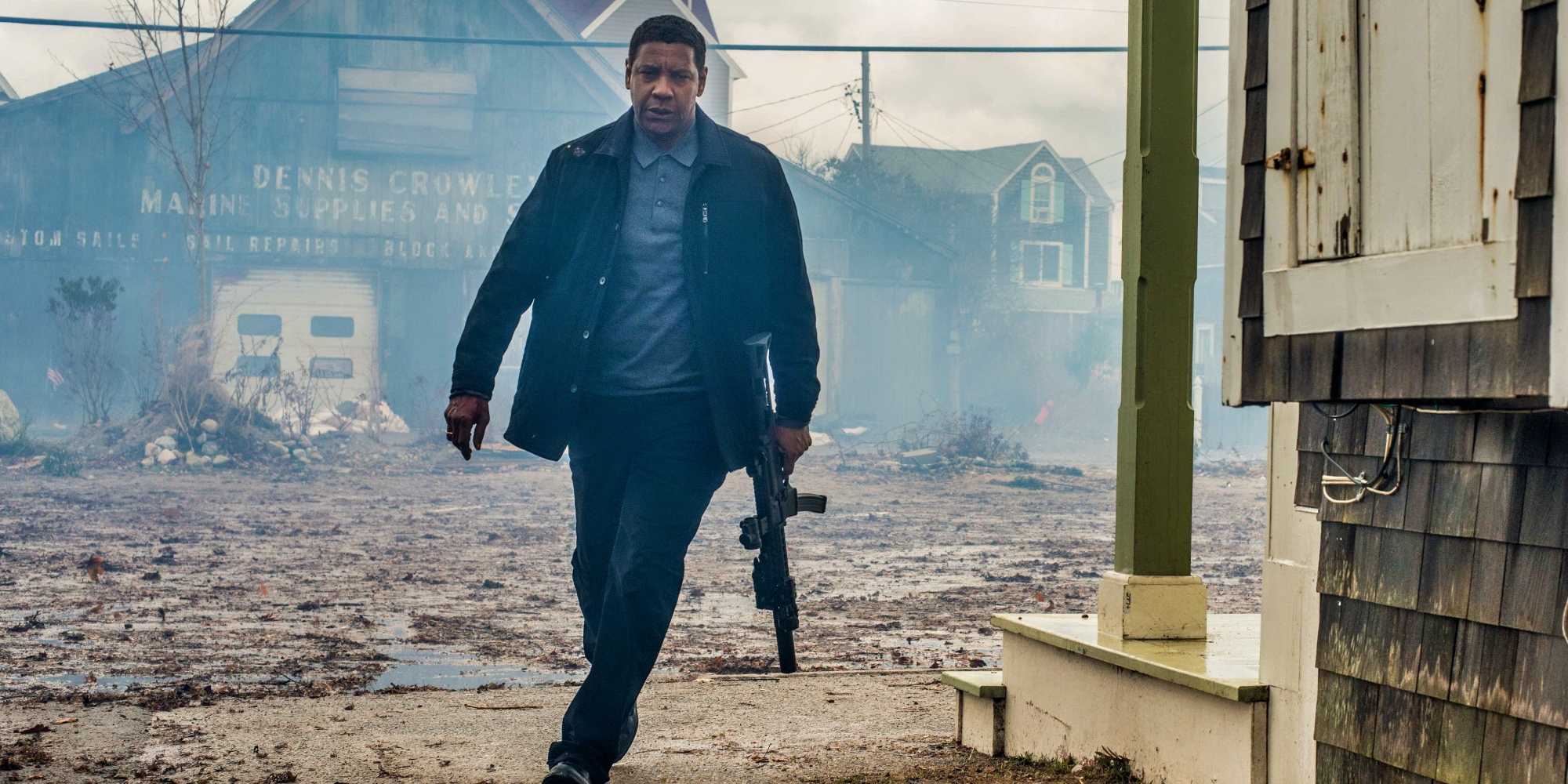 Маккал идет среди обломков с пулеметом в фильме "The Equalizer 2"