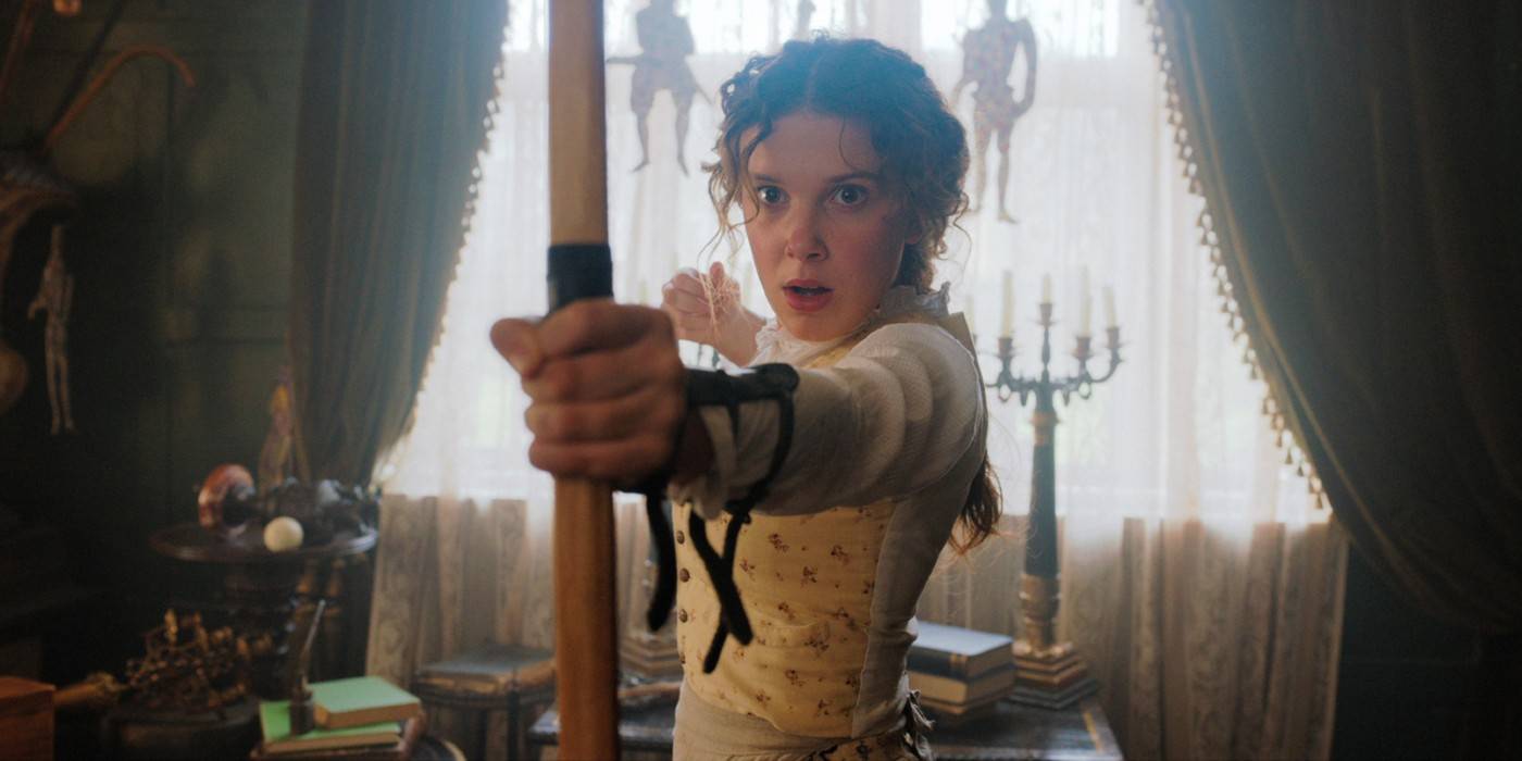 Милли Бобби Браун в роли Энолы Холмс с луком.