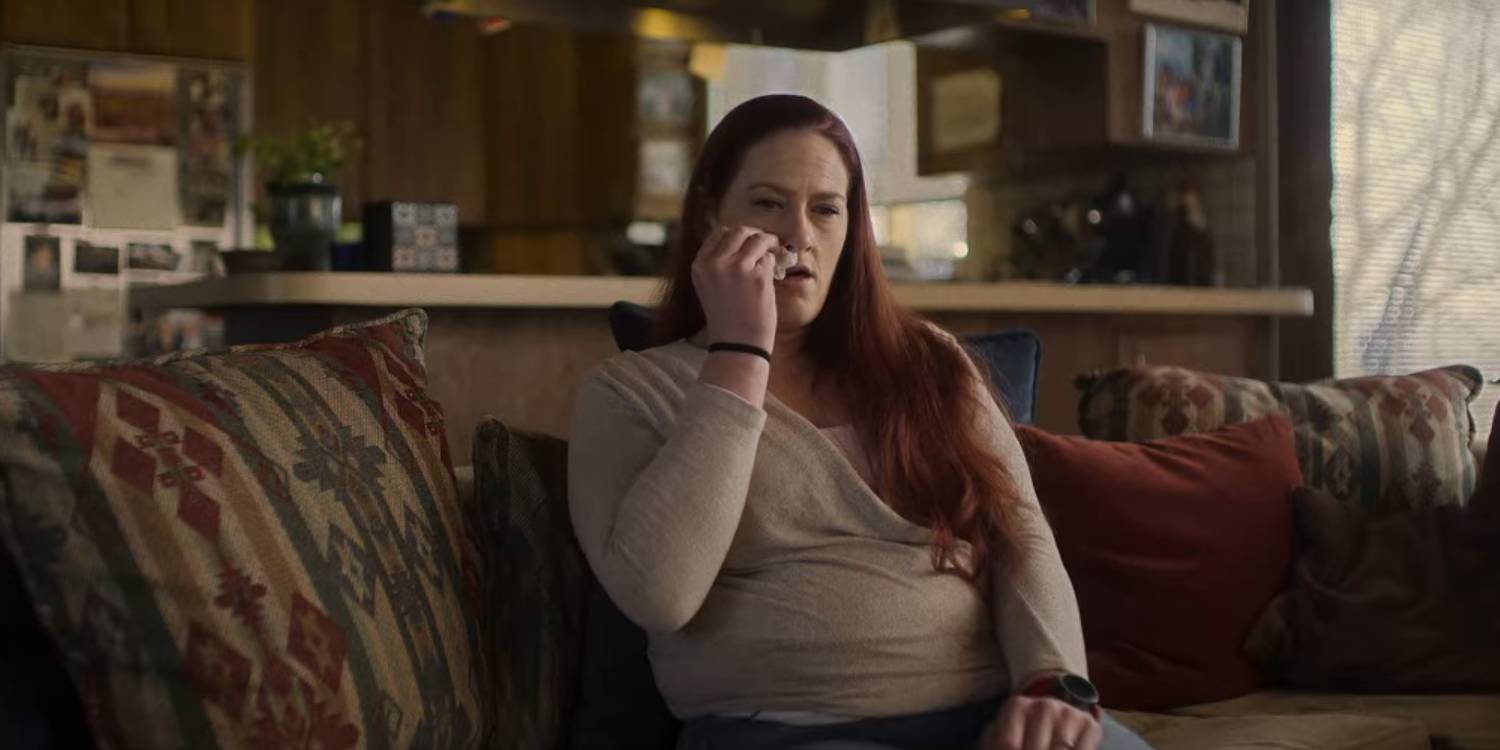 Эмбер вытирает слезы, сидя на диване в Hell Camp: Teen Nightmare.