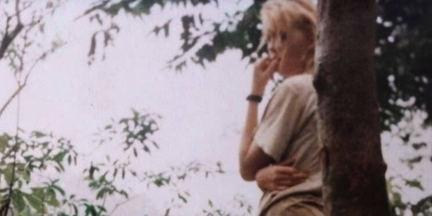 Подросток прислонился к дереву, глядя в сторону в "Hell Camp".