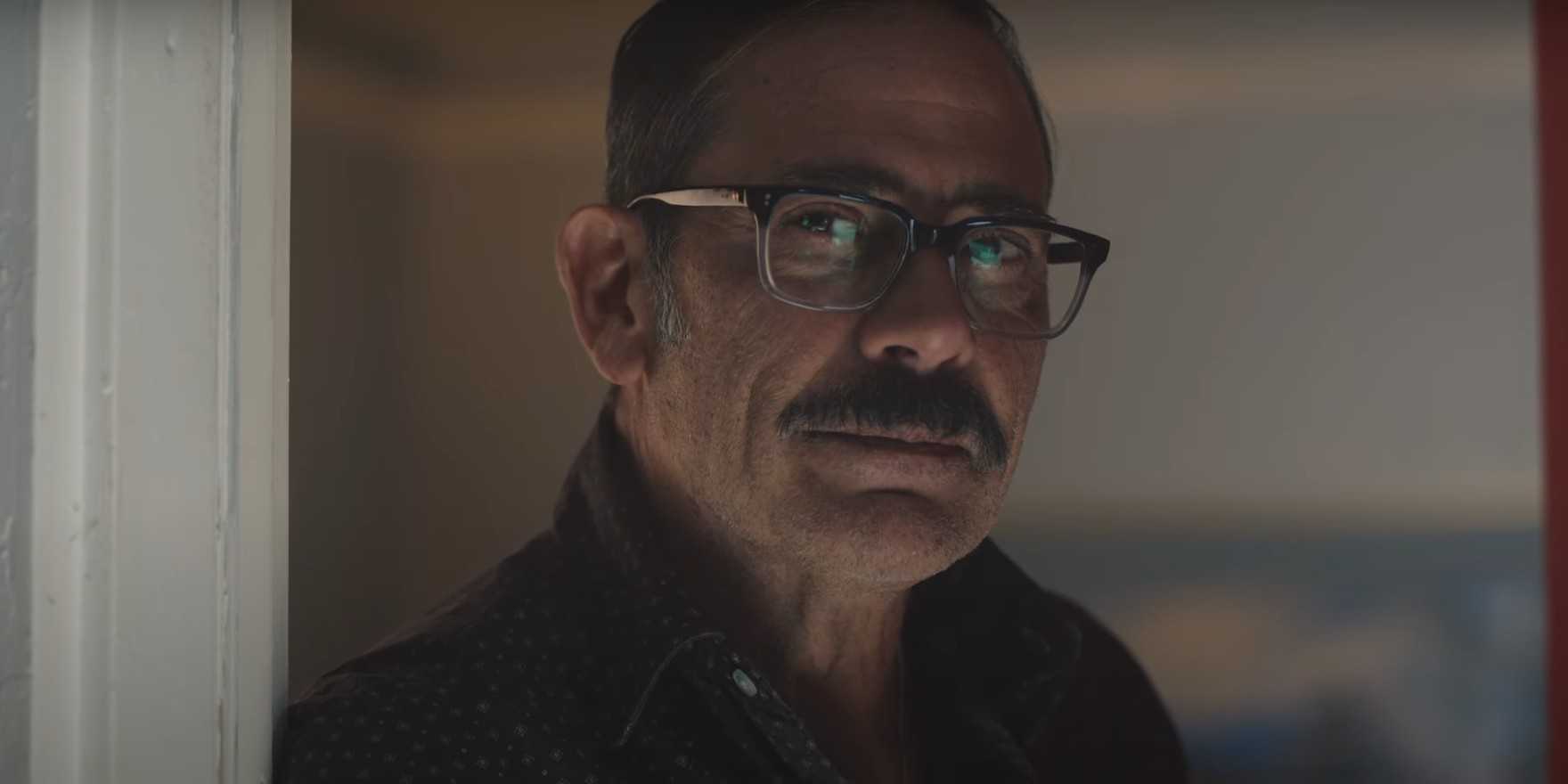 Джеффри Дэн Морган смотрит на кого-то с легкой усмешкой в "Соседском дозоре"