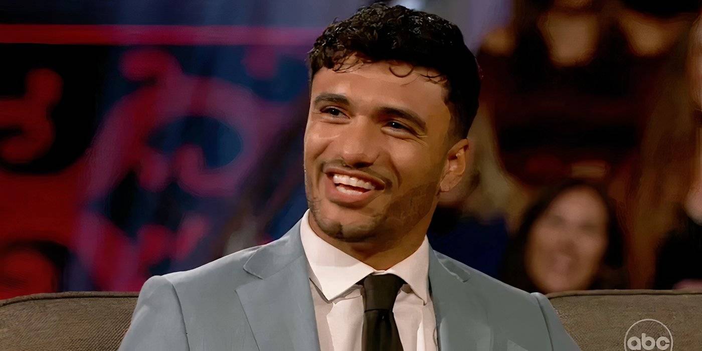 Улыбающийся Джонни Джонсон, участник *The Bachelorette*, в сером костюме. *Bachelor In Paradise*