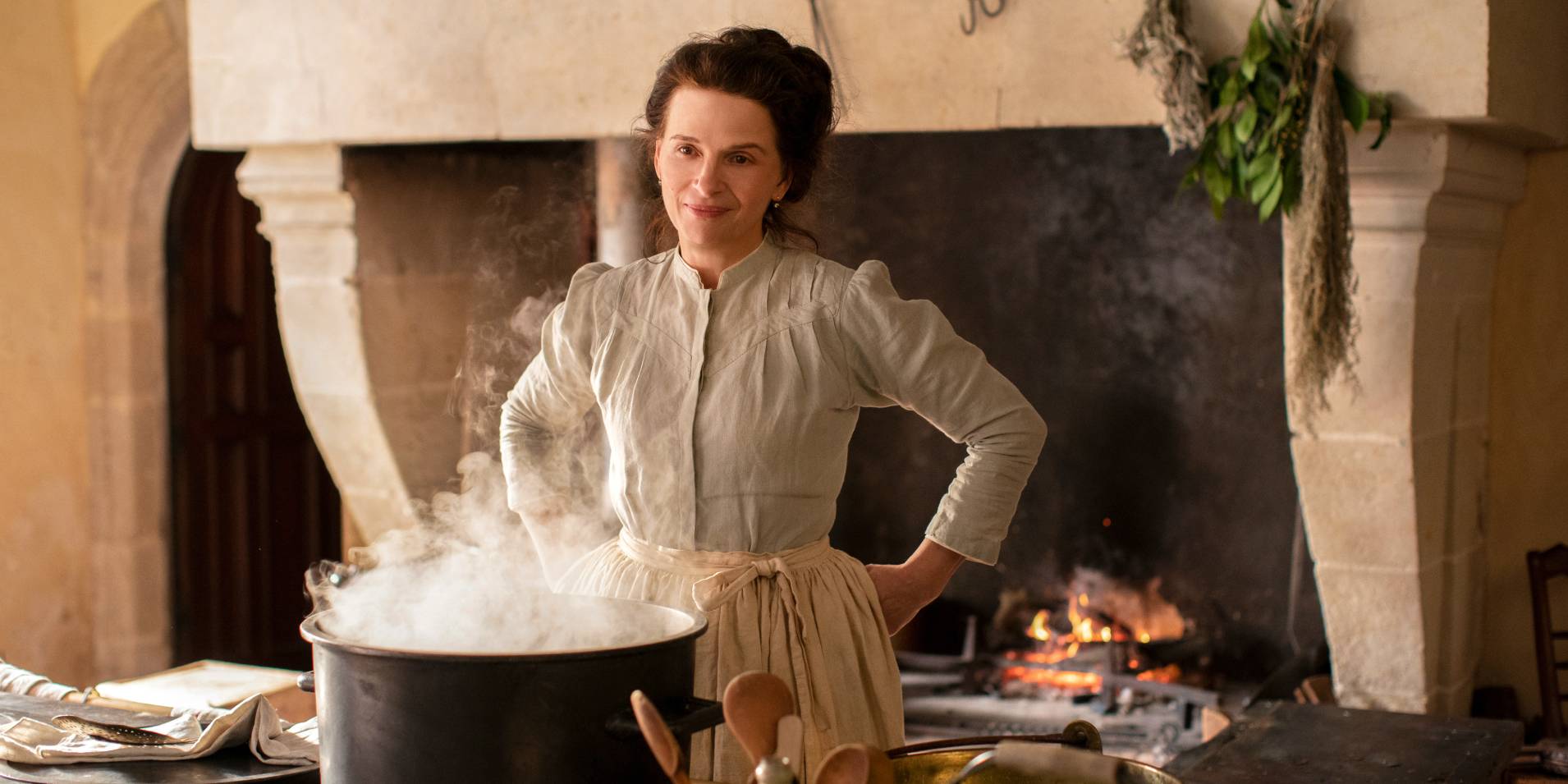 Жюльетт Бинош стоит над кипящим котлом на кухне в фильме "Вкус вещей"