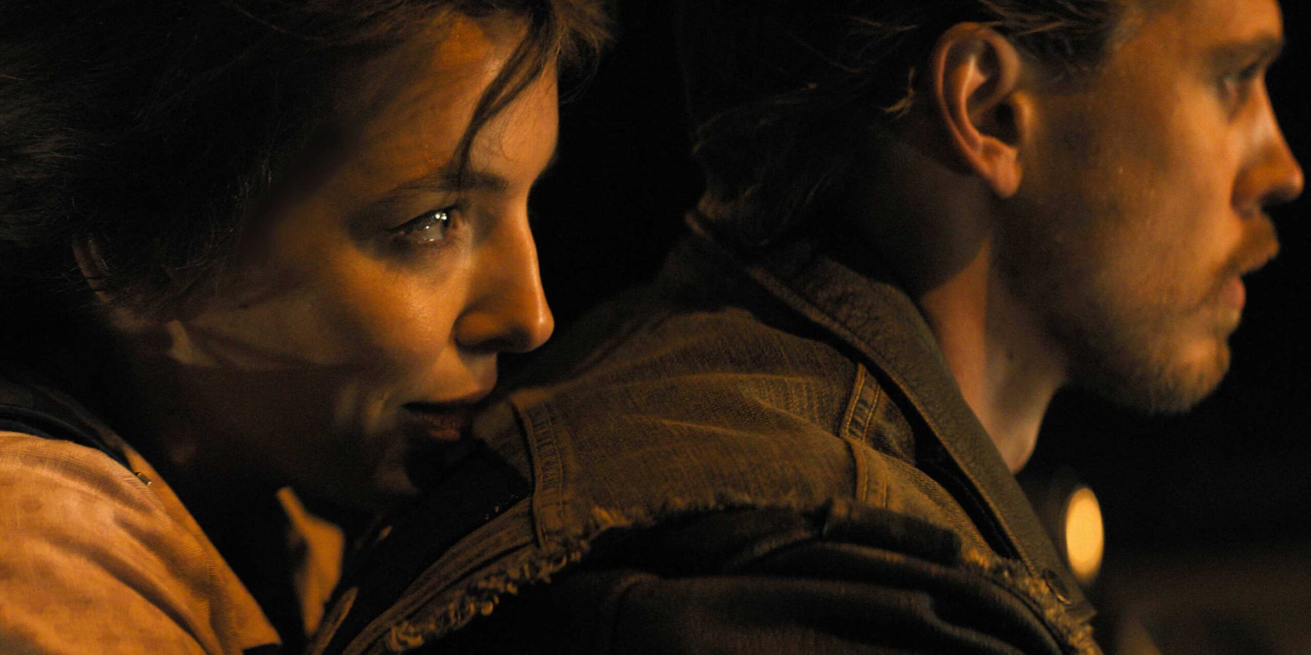 Кэти улыбается, держась за Бенни, когда он едет на мотоцикле в фильме The Bikeriders