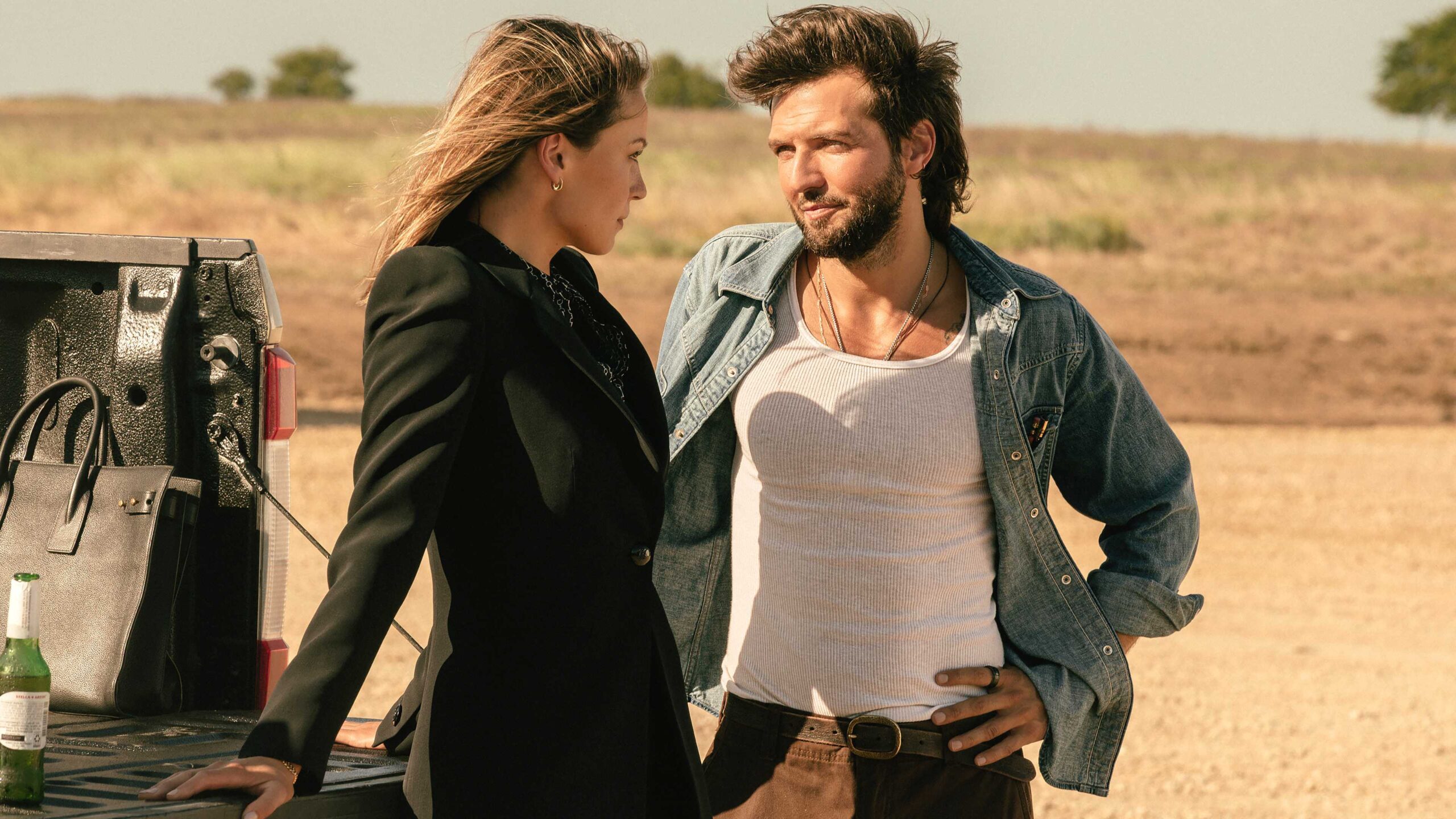 Рекка из "Landman" (Кайла Уоллес) и Чарли из "Landman" (Гай Бернет) обнимаются возле грузовика в 2-м сезоне "Landman"