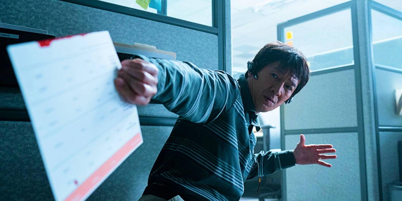 Ке Хуй Куан держит настольный календарь в боевой позе в фильме "Вселенная, везде и сразу"