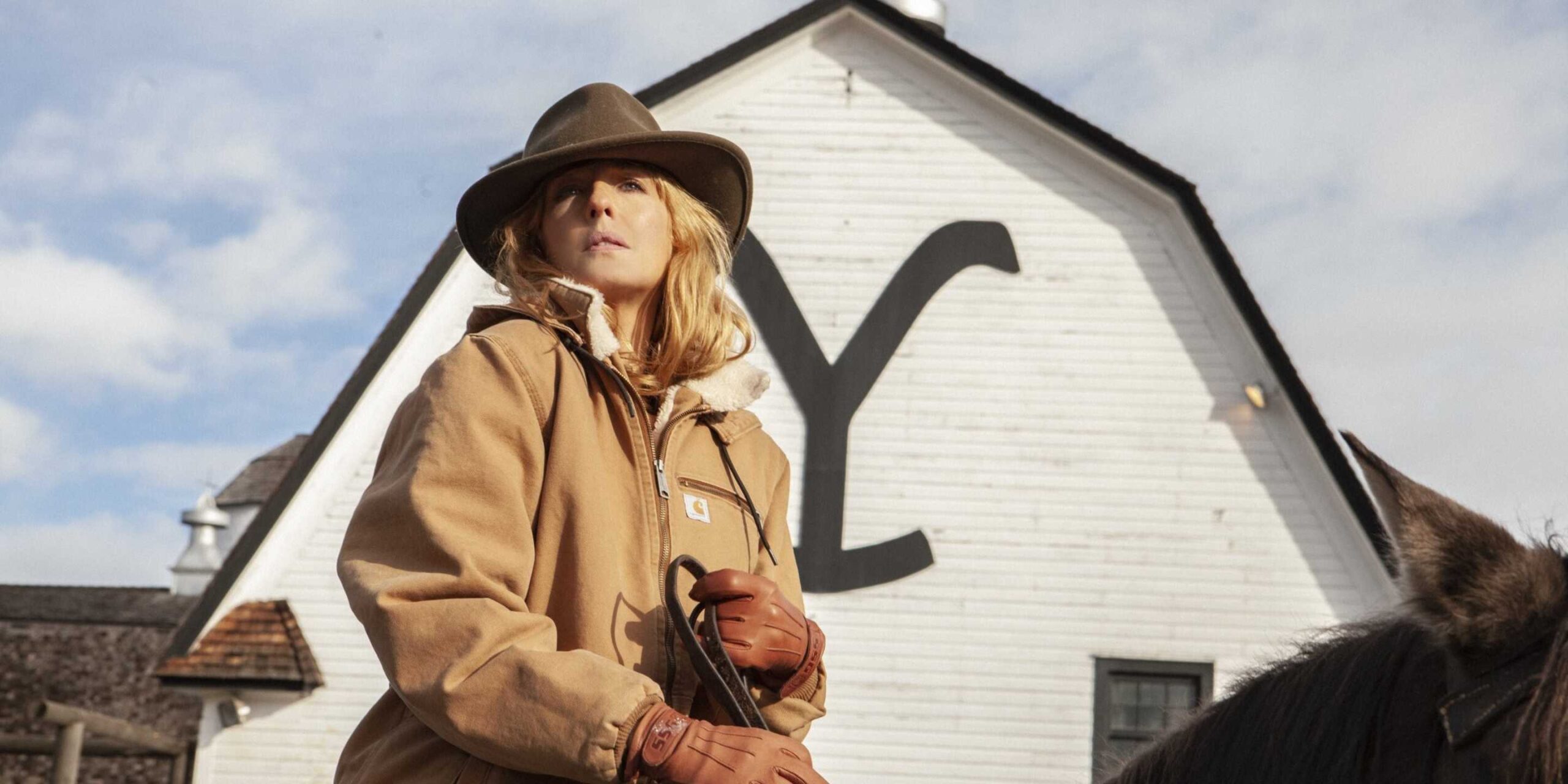Келли Райли верхом на лошади перед ранчо "Yellowstone".