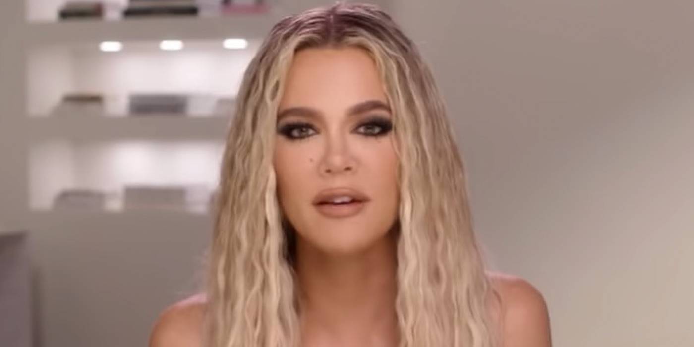 Клои Кардаш из "The Kardashians" с светлыми кудрявыми волосами, серьезно смотрящая.