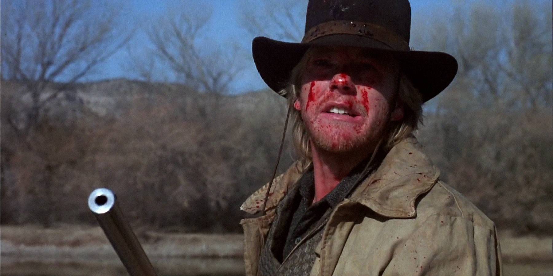 Кифер Сазерленд с винтовкой и покрытый кровью в Young Guns
