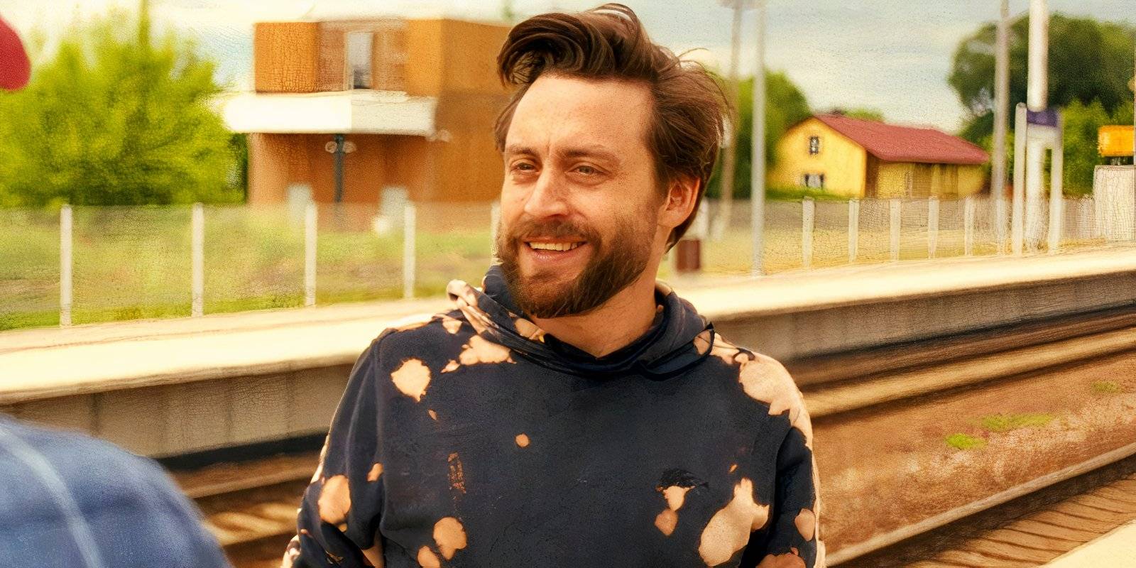 Кieran Culkin улыбается на вокзале в фильме "A Real Pain"