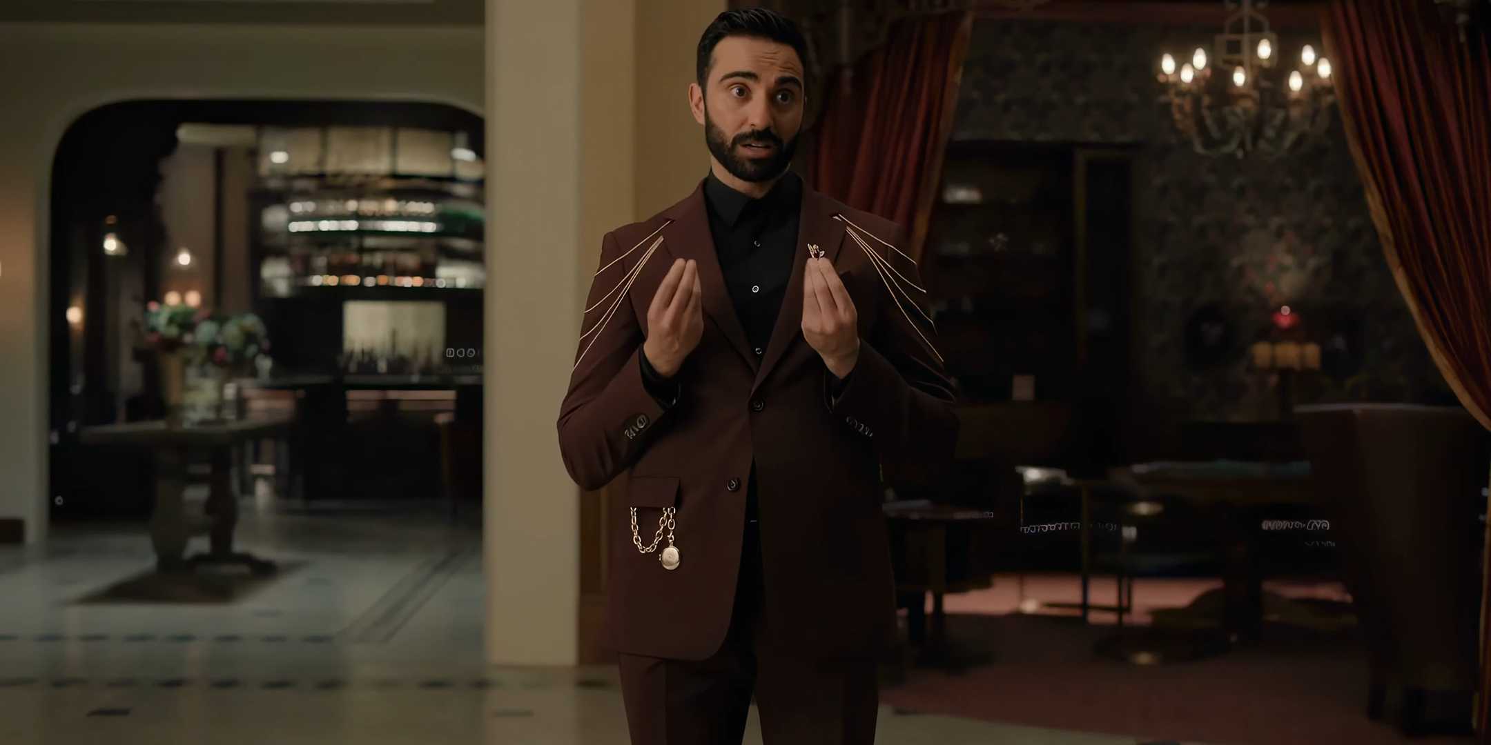 Ли Маджоуб в роли Джитенды, серьезно смотрит на камеру, с руками у себя в груди в 4 сезоне "Upload"