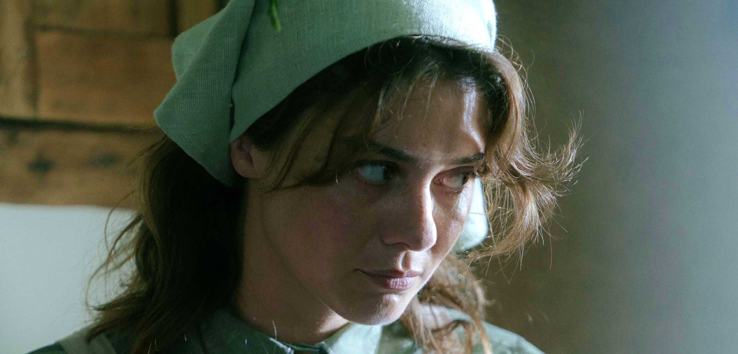 Magpie Severed Sun looking off to the side while wearing a bonnet 