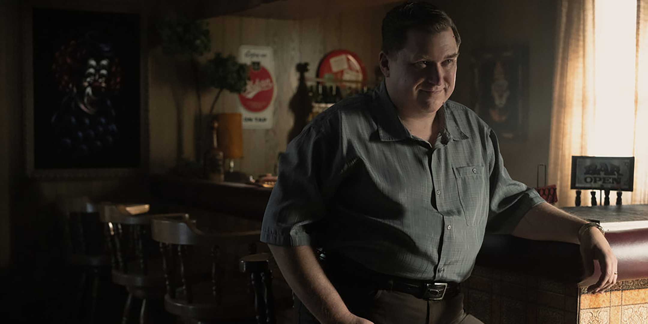 Майкл Чернус в роли Джона Уэйна Гаси, сидящего в баре и загадочно улыбающегося в «Devil in Disguise: John Wayne Gacy»