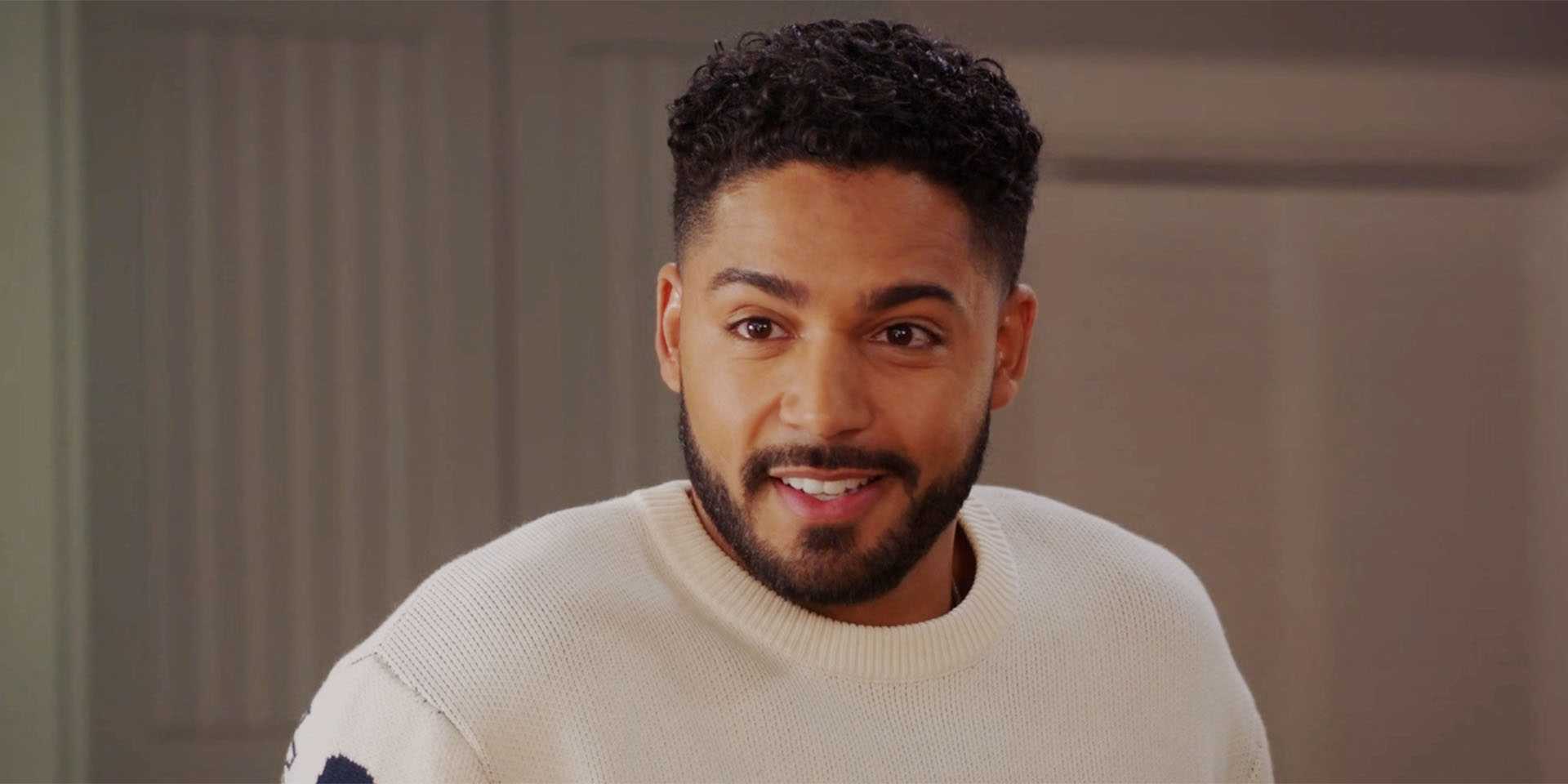 Микел Эванс Белинг улыбается в 6 сезоне сериала "All American", разговаривая с кем-то