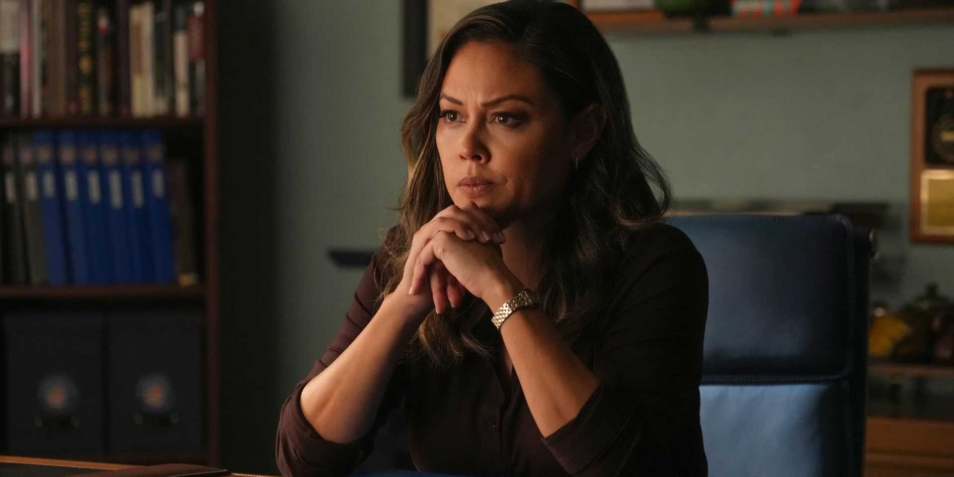 Jane Tennant из NCIS Hawai'i, задумчиво смотрит, руки сложены.