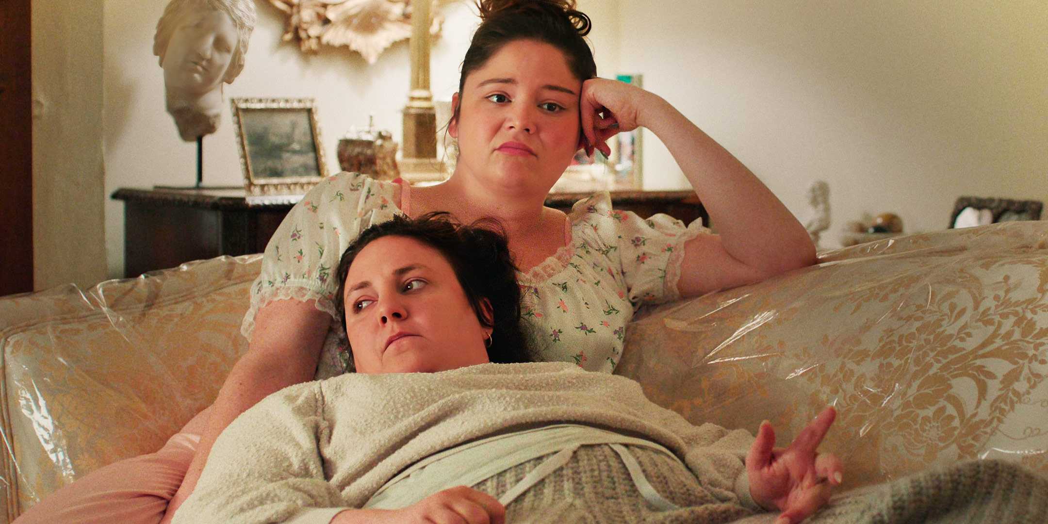 Лена Данхэм и Меган Стальтер лежат на диване в сериале "Too Much" от Netflix