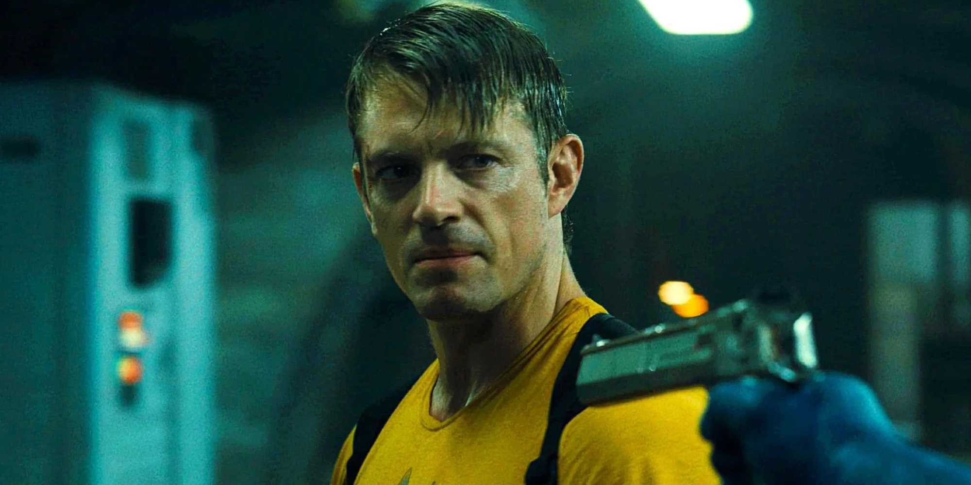 Рик Флаг, выглядящий сердито, когда Миротворец направляет на него оружие в "Миротворец" (2021)