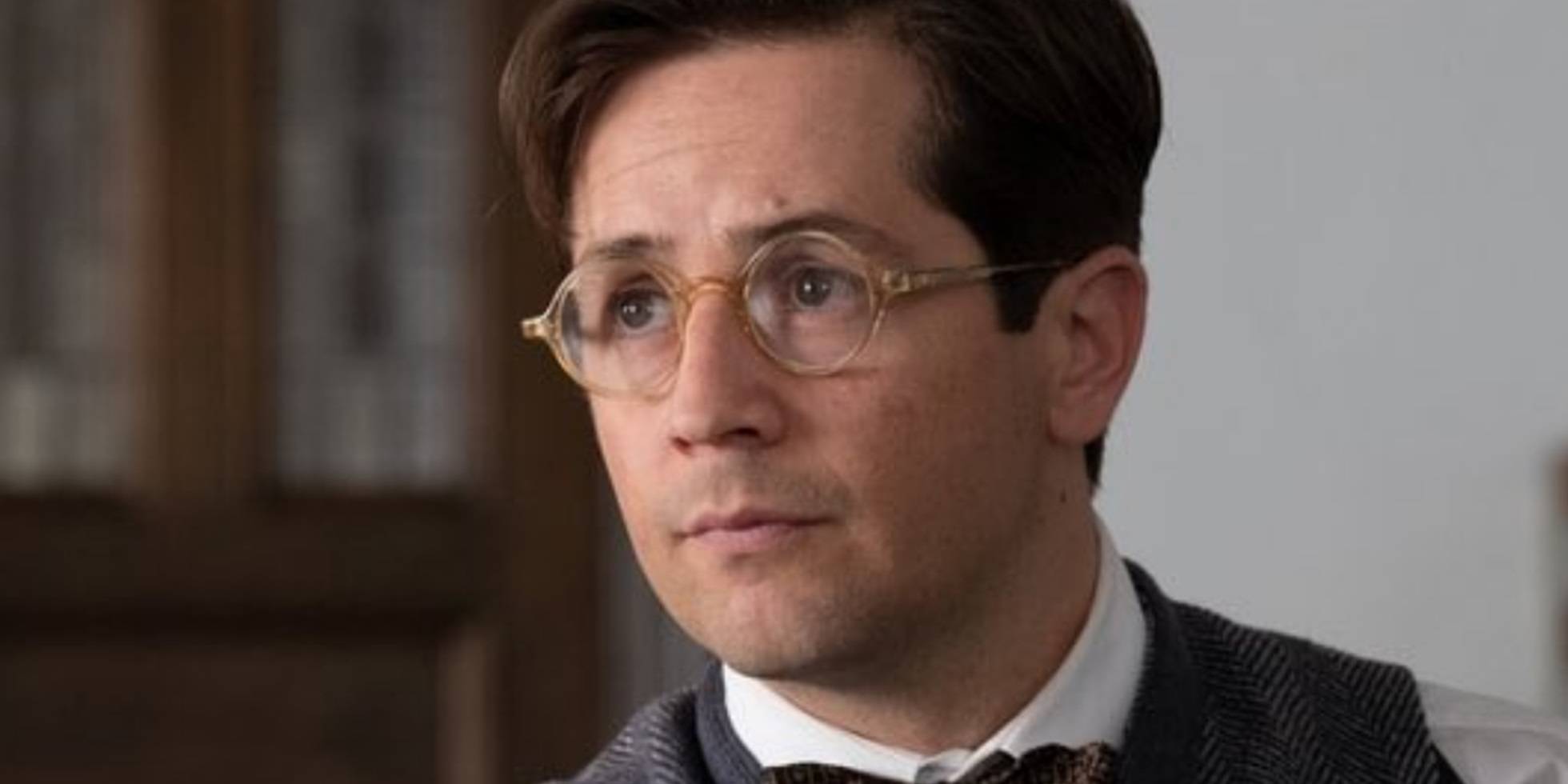 Роберт Сербер (Майкл Анграно) носит очки и смотрит в сторону в *Оппенгеймере*