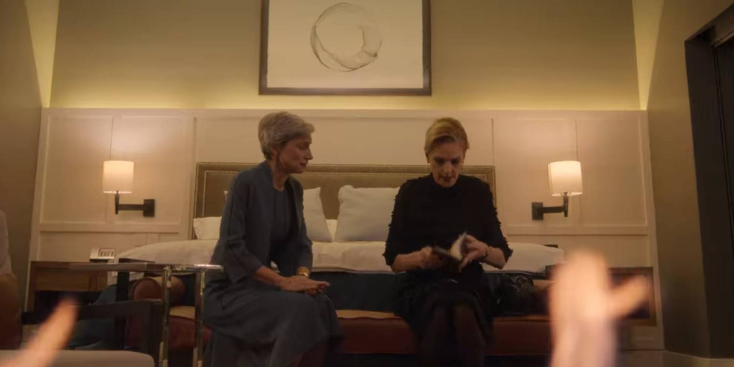 Два персонажа сидят у подножия своей кровати перед камином.