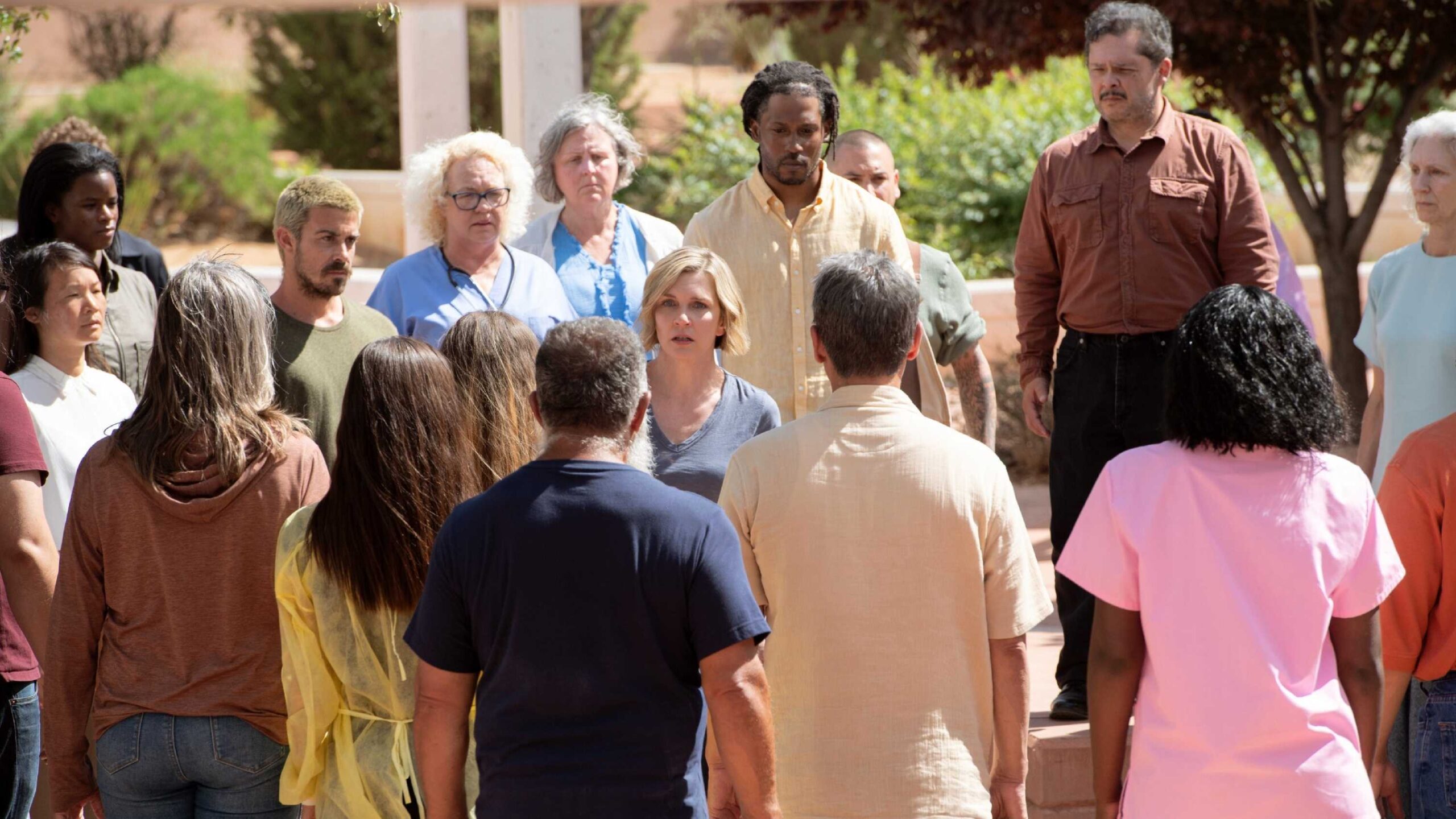 Множество членов коллективного разума, собравшихся вокруг Карл Стёрка (Рейа Сихрн) в сериале "Pluribus"