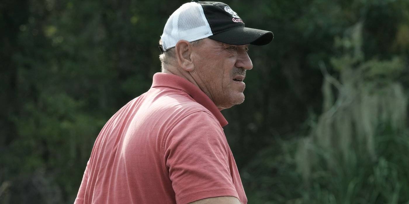 Трой Ландри, Swamp People, на лодке, выглядит обеспокоенным в розовой рубашке и шляпе