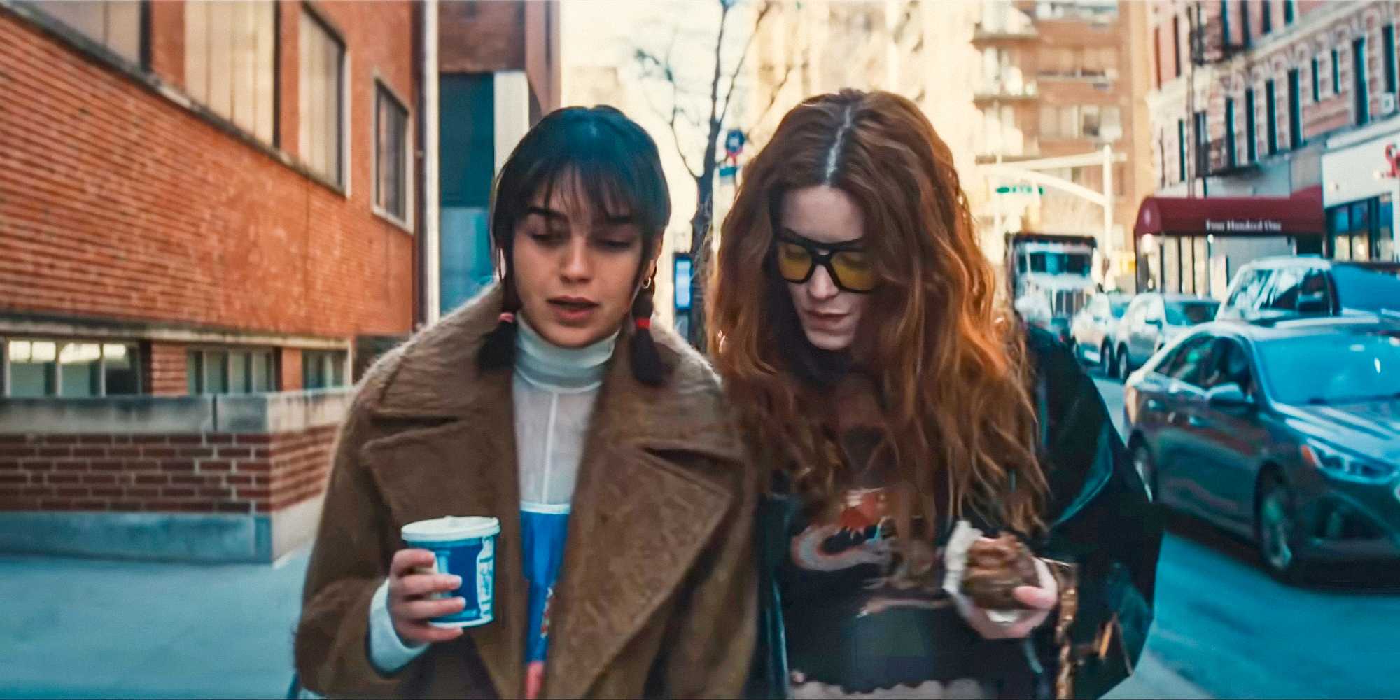 Лорре (Мелисса Баррера) и Мейзи (Кейла Фостер) идут по улице, попивая кофе в "Твой монстр"